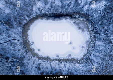 Petit lac gelé en forêt en hiver. Vue aérienne de la nature en hiver. Banque D'Images