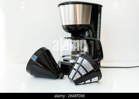 Cafetière goutte-à-goutte automatique isolée sur une table blanche. Cafetière goutte-à-goutte moderne noire. Cuisine électrique petits appareils ménagers. Appareils Banque D'Images