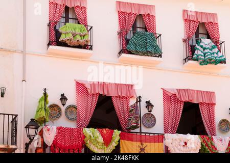 Des robes de flamenco espagnoles colorées pendent et sèchent sur le balcon d'une place dans le centre de la vieille ville de Marbella en Espagne. Banque D'Images