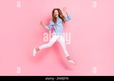 Portrait complet de la personne pleine d'énergie surjoyeuse sautant lever les mains isolées sur fond de couleur rose Banque D'Images