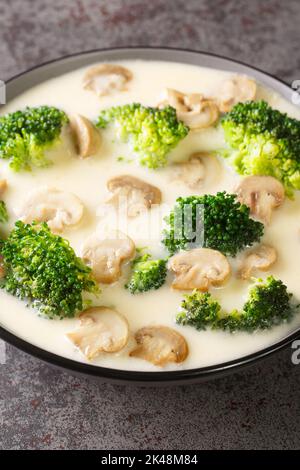 Bol avec une délicieuse soupe aux champignons avec de la crème et du brocoli en gros plan sur la table. Verticale Banque D'Images