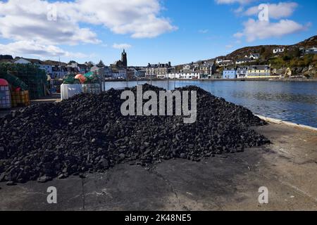 Une pile de charbon attend sur le quai dans le port à East Loch Tarbert. East Loch Tarbert, Argyll et Bute Banque D'Images