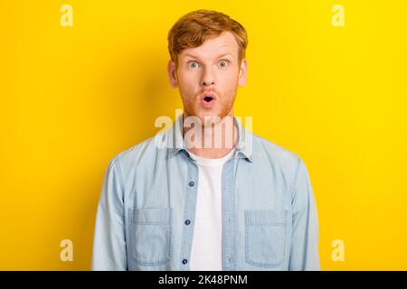 Photo portrait de beau jeune gars modèle étonnement impressionné nouvelles ventes porter élégant jeans vêtements isolés sur fond jaune couleur Banque D'Images