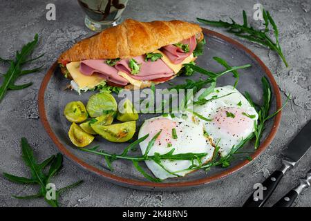 Petit-déjeuner avec œufs frits et croissant sandwith avec jambon, fromage et salade. Délicieux petit déjeuner Banque D'Images