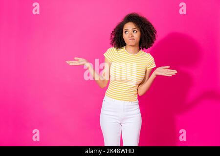 Portrait photo de jeune femme belle porter t-shirt haussement d'épaules paumes aucune idée ne sais pas chercher vide espace isolé sur fond rose couleur Banque D'Images