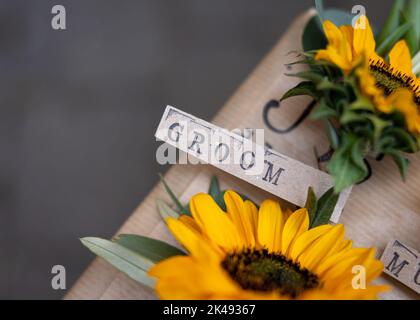 Badge de nom de marié avec police de texte imprimée sur fleur de tournesol faveur. De belles fleurs pour les hommes de gémissement à porter le grand jour. Jaune et salles de réunion Banque D'Images