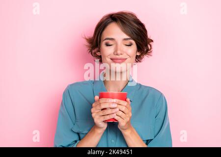 Photo portrait de belle jeune dame appréciez frais chaud goût cacao arôme fermé yeux porter élégant bleu look isolé sur fond rose couleur Banque D'Images