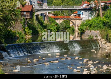 Rivière Selska Sora avec cascade d'eau et ponts dans la ville de Skofja Loka en Slovénie, la passerelle la plus proche de Novi loski et le pont historique de Capuchin Banque D'Images