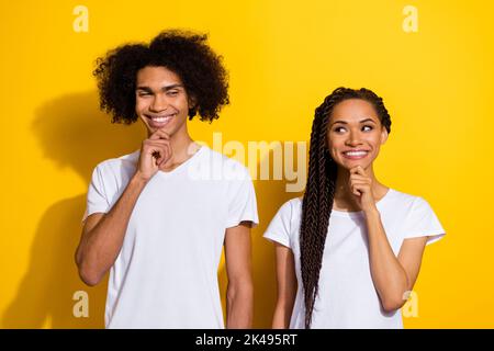 Portrait de deux personnes funky positif main tactile menton look intéressé l'un l'autre isolé sur fond jaune couleur Banque D'Images