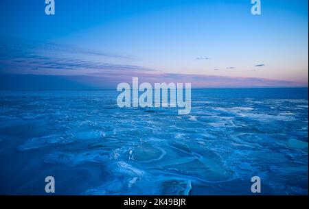 Vue aérienne du coucher de soleil sur la mer gelée. Paysage hivernal sur la mer au crépuscule. Vue depuis le dessus de la fonte de glace dans l'océan au lever du soleil avec horizon Banque D'Images