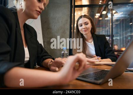 Une employée de l'entreprise discute de questions commerciales avec son collègue Banque D'Images