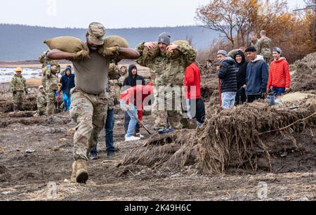 Koyuk, États-Unis. 28th septembre 2022. Des soldats américains de la Garde nationale de l'Alaska et des citoyens locaux aident à emballer des sacs de sable pour protéger la côte à l'entrepôt autochtone de Koyuk, à la suite du typhon Merbok, 28 septembre 2022, à Koyuk, en Alaska. Les villages côtiers autochtones éloignés de l'Alaska ont subi des dommages en raison des restes du cyclone qui a inondé plus de 1 000 milles de côtes de l'Alaska. Crédit : Sgt. Seth LaCount/US Army/Alamy Live News Banque D'Images