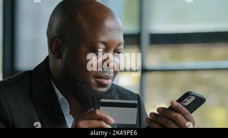 Homme d'affaires de client africain entrant des données de carte de crédit utiliser le code de sécurité pour le transfert d'argent électronique douleur services en ligne des paiements sûrs en mobile Banque D'Images