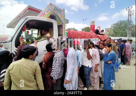 Les gens se rassemblent pour acheter des sacs de farine sur le prix des subventions d'un magasin d'utilité mobile vendu par le gouvernement de Sindh, comme le prix des articles généraux utilisés quotidiennement ont touché le ciel en raison de la hausse des prix dans le pays, dans la région de Nazimabad à Karachi samedi, 01 octobre 2022. Banque D'Images