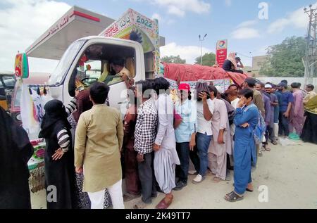 Les gens se rassemblent pour acheter des sacs de farine sur le prix des subventions d'un magasin d'utilité mobile vendu par le gouvernement de Sindh, comme le prix des articles généraux utilisés quotidiennement ont touché le ciel en raison de la hausse des prix dans le pays, dans la région de Nazimabad à Karachi samedi, 01 octobre 2022. Banque D'Images