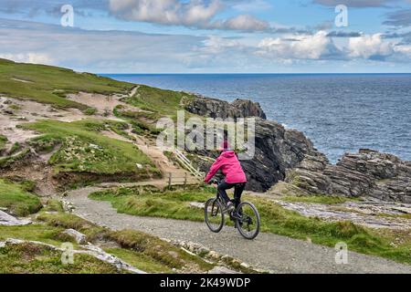 Belle femme senior en VTT, en vélo sur les falaises de Malin Head, le point le plus au nord de l'Irlande Banque D'Images