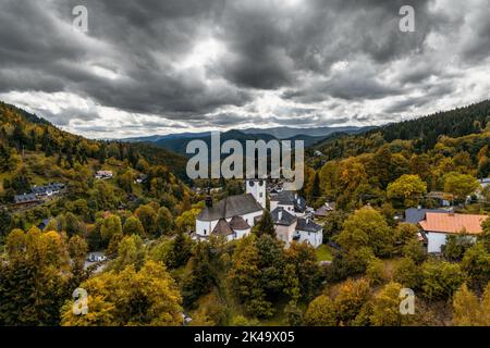 Spania Dolina, Slovaquie - 28 septembre 2022 : vue sur le village et l'église catholique romaine de Spania Dolina avec forêt d'automne colorée Banque D'Images