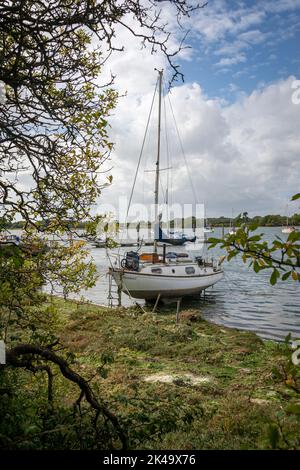 Petit bateau à voile amarré sur un quai de boue à Dell Quay, Chichester Harbour, Royaume-Uni Banque D'Images