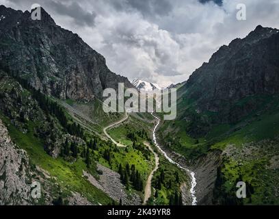 Magnifique paysage de montagnes avec glacier de neige et rivière à la tempête gris ciel nuageux coucher de soleil à Almaty, Kazakhstan. Concept de randonnée et de plein air, Banque D'Images