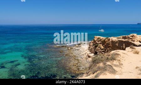 Vue panoramique de Cala Saona sur l'île de Formentera avec un voilier ancré près de la plage. Espagne Banque D'Images