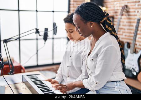 La mère et le fils afro-américains qui apprennent à jouer du piano au studio de musique Banque D'Images