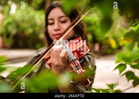 Fille avec son violon jouant une mélodie à l'extérieur, concept de violoniste féminine souriante. Belle fille jouant le violon à l'extérieur. Portrait d'une fille Banque D'Images