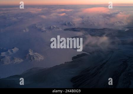 Photos aériennes uniques du paysage hivernal gelé et enneigé des montagnes et de la côte du Svalbard, prises depuis un avion / drone au coucher du soleil Banque D'Images