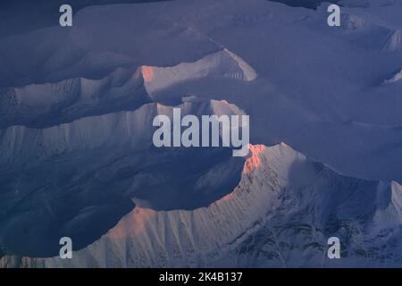 Photos aériennes uniques du paysage hivernal gelé et enneigé des montagnes et de la côte du Svalbard, prises depuis un avion / drone au coucher du soleil Banque D'Images