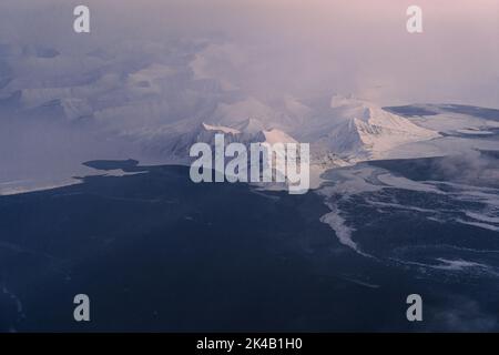 Photos aériennes uniques du paysage hivernal gelé et enneigé des montagnes et de la côte du Svalbard, prises depuis un avion / drone au coucher du soleil Banque D'Images