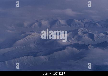 Photos aériennes uniques du paysage hivernal gelé et enneigé des montagnes et de la côte du Svalbard, prises depuis un avion / drone au coucher du soleil Banque D'Images