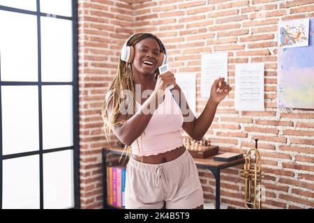 Femme afro-américaine écoutant de la musique chantant à la maison Banque D'Images