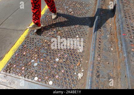 Une personne se promène au-dessus d'une voûte-trottoir en fonte originale de New York, incrustée de perles de verre colorées, située dans le quartier SoHo de Manhattan. Banque D'Images