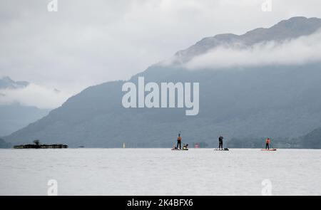 Journée de paddleboard en famille avec un chien Banque D'Images