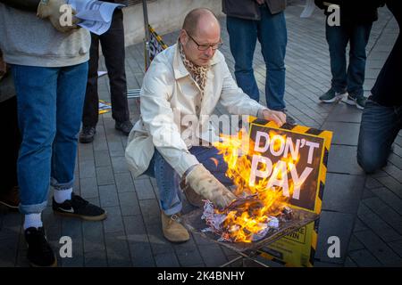 Londres, Royaume-Uni. 1st octobre 2022. Les manifestants brûlent leurs factures d'énergie, dans le cadre de la campagne Don't Pay, exhortant les gens à ne pas payer leurs factures d'énergie pour protester contre la flambée des coûts. Des gens, ainsi que divers groupes et syndicats se sont rassemblés devant la mairie de Lewisham pour protester contre la crise du coût de la vie, la crise climatique, la hausse des factures d'énergie et le gouvernement conservateur, et en solidarité avec les diverses grèves qui ont lieu dans tout le Royaume-Uni. Photo Horst A. Friedrichs Alamy Live News Banque D'Images