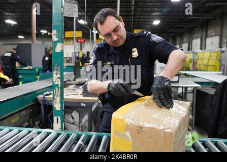 Agents le U.S. Customs and Border Protection, Bureau des opérations de terrain, l'écran des paquets pour contrefaçon de produits expédiés dans la région puisqu'ils participent à des opérations de sécurité précédant le Super Bowl IIL à Minneapolis, au Minnesota, le 29 janvier 2018. U.S. Customs and Border Protection photo par Glenn Fawcett Banque D'Images