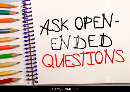 Posez des questions ouvertes écrites sur la page du bloc-notes, crayon rouge sur la droite. Image de concept de motivation. Banque D'Images