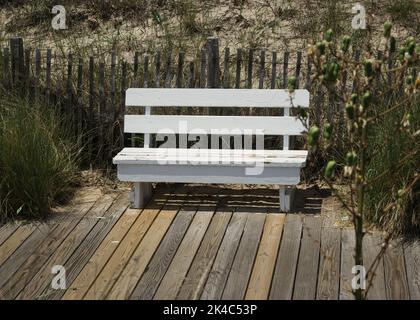 Un banc en bois blanc à la promenade de la plage Banque D'Images