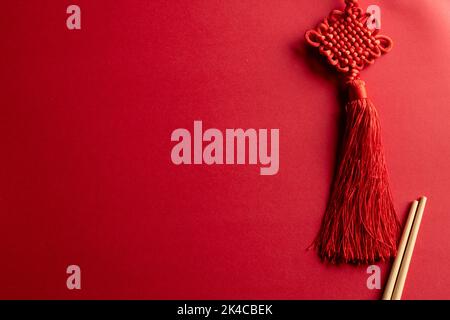 Composition de décorations et baguettes chinoises traditionnelles sur fond rouge Banque D'Images