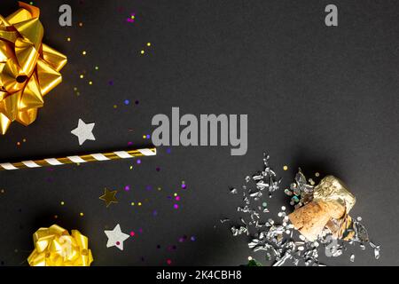 Composition de gros plan de champagne du nouvel an et confetti sur fond noir Banque D'Images