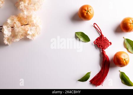 Composition de fleurs, décorations et oranges sur fond blanc Banque D'Images
