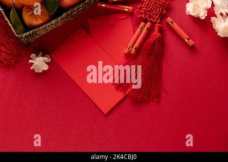 Composition de décorations chinoises traditionnelles et de fleurs sur fond rouge Banque D'Images