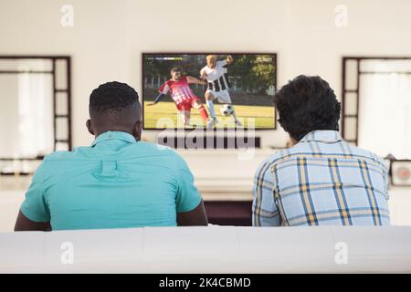 Divers amis regardant la télévision avec un match de football à l'écran Banque D'Images