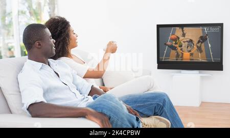 Couple sitting on couch ensemble à la maison à regarder la télévision dans le salon Banque D'Images
