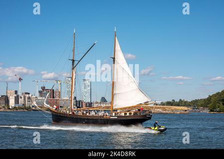 Homme à bord d'un jet de ski passant par Yawl Ingeborg sur Kruunuvuorenselkä à Helsinki, en Finlande Banque D'Images