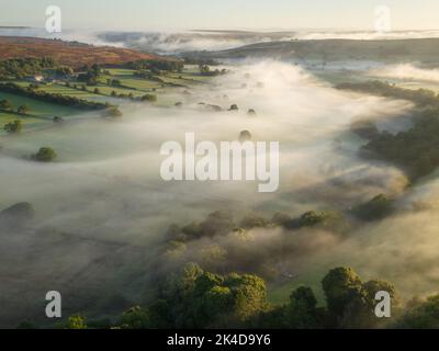 Une inversion de température entraînant un brouillard le long du fond de la vallée, qui s'est effacé en très peu de minutes après le lever du soleil. Banque D'Images