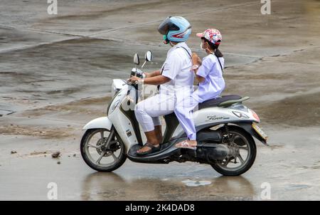 SAMUT PRAKAN, THAÏLANDE, SEP 26 2022, Une femme fait une moto sous la pluie avec un enfant Banque D'Images