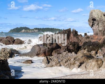 Vagues se brisant autour de la base rocheuse du mont Maunganui Banque D'Images