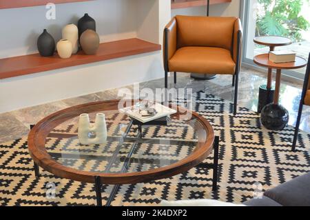 Double table en bois brun, avec bords métalliques circulaires et plusieurs étagères en verre. Banque D'Images