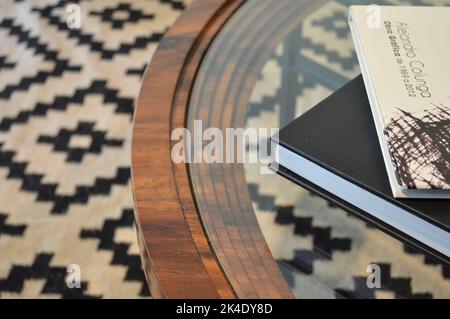 Double table en bois brun, avec bords métalliques circulaires et plusieurs étagères en verre. Banque D'Images