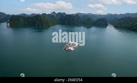 Croisière aérienne en yacht blanc de luxe, ancrée dans la baie d'Ha long Vietnam par beau temps Banque D'Images